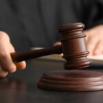 Judge’s Staggering Mistake: Predator Disappears! A judge's hand holding a gavel above a wooden block