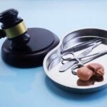 Outrage Erupts: Doctor’s 5-Year Sentence for Forced Abortion A gavel next to a surgical tray containing medical instruments and an anatomical model