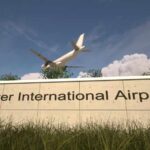 Runway Horror Stuns Denver Airport Sign for Denver International Airport with an airplane flying overhead