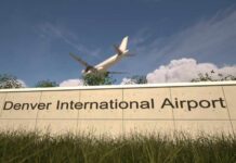Sign for Denver International Airport with an airplane flying overhead