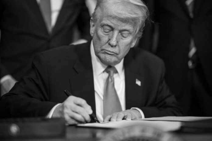 A man in a suit signing a document with a focused expression