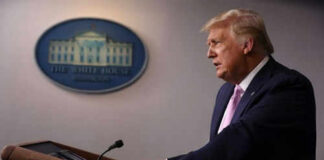 Person speaking at a podium with White House emblem