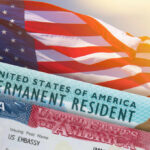 Constitution Rewrite: Naturalized Americans OUT? U.S. flag with visa and permanent resident card in foreground