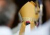 Bishop wearing a golden mitre during a ceremony