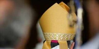 Bishop wearing a golden mitre during a ceremony