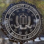 Ambassador Turned Mole Shocks Washington FBI seal on a concrete wall outdoors