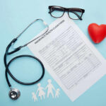 Health claim form with stethoscope and eyeglasses displayed