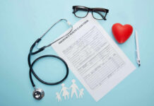 Health claim form with stethoscope and eyeglasses displayed