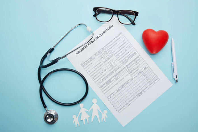 Health claim form with stethoscope and eyeglasses displayed
