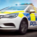 Police car driving with flashing lights visible