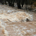 Flooded river with muddy, turbulent water