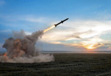 Rocket launching over a field at sunset