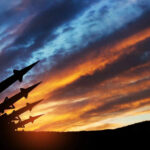Chinese Missile Suspected—U.S. Jet Downed Silhouette of missiles against dramatic sunset sky.