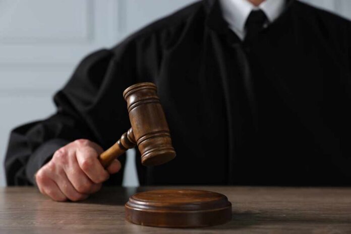A judge holding a gavel above a wooden block