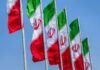 Peace Deal Panic: Israel Sidelined Multiple Iranian flags waving against a clear blue sky