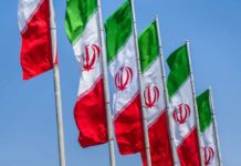 Peace Deal Panic: Israel Sidelined Multiple Iranian flags waving against a clear blue sky
