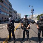 Police officers in riot gear standing on a street during a protest