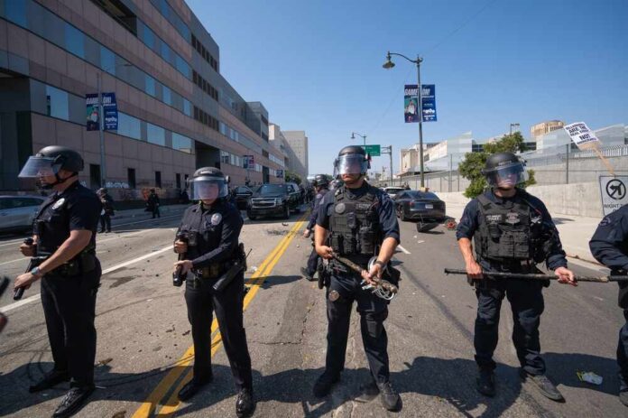 Police officers in riot gear standing on a street during a protest