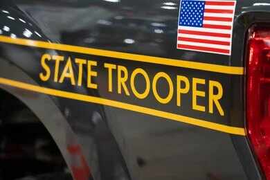New York State Police cruiser side with emblem and yellow stripe