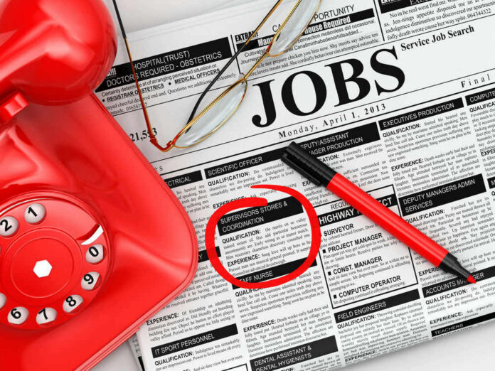 23920653 Job classifieds with phone, pen, and glasses.