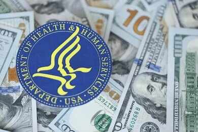 HHS seal on a pile of US dollar bills