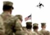 US Army Prepares For Drone Wars Soldier saluting from atop a tank with an Israeli flag in the background