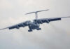 Large airplane flying in cloudy sky, frontal view.