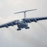 China’s Biggest Military Upgrade Yet? Large airplane flying in cloudy sky, frontal view.