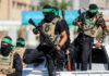 Hamas Announces Major Gaza Shift Masked men with firearms standing on a vehicle