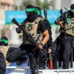 Hamas Announces Major Gaza Shift Masked men with firearms standing on a vehicle