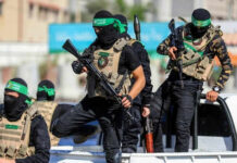 Hamas Announces Major Gaza Shift Masked men with firearms standing on a vehicle