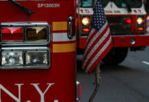 Construction Crisis Hits Former Pfizer Tower Fire trucks with American flag, New York City.