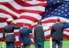 Veterans Call Shutdowns Dangerous For America Veterans salute a large American flag