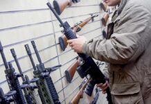 Court Just Saved Your Gun Rights? Person examining a black rifle in a gun store