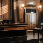 Texts And Note Dominate Kirk Hearing Interior view of a courtroom with wooden benches and large murals