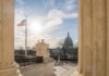 Victory Spins Into Court-Packing Push U.S. Capitol seen between marble columns with flag and statue in foreground