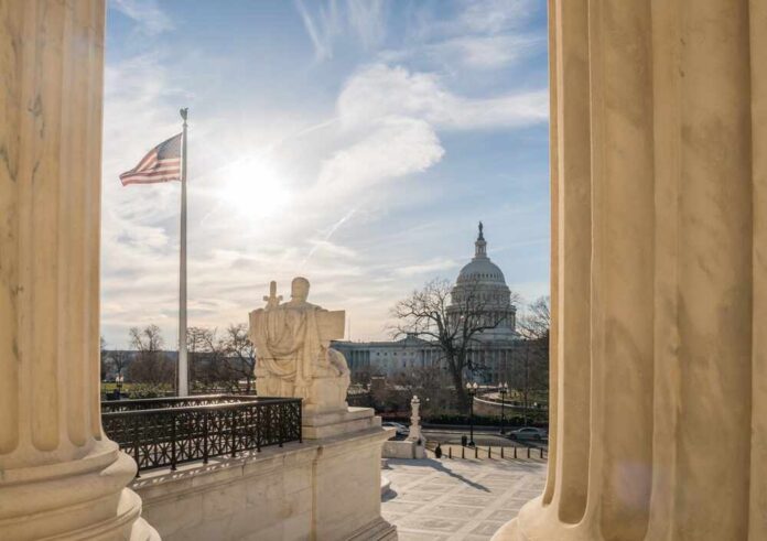 Washington,,Dc,,Us-february,6,,2023:,View,Of,The,Us,Capitol U.S. Capitol seen between marble columns with flag and statue in foreground