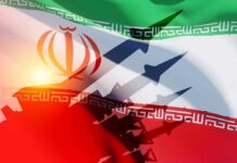 Iran Pummeled — But What’s The Endgame? Iranian flag with silhouettes of missiles and military vehicles