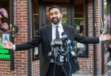 What Zohran Mamdani Actually Skipped Man in a suit speaking at outdoor press conference with multiple microphones