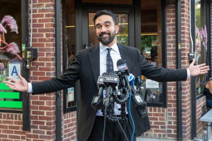 Democratic,New,York,City,Mayoral,Candidate,Zohran,Mamdani,Appears,At Man in a suit speaking at outdoor press conference with multiple microphones