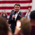Texas Democrat’s Faith Remarks Spark Backlash Speaker in a suit addressing an audience with a microphone