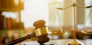 Judge's gavel on a block with scales of justice in the background