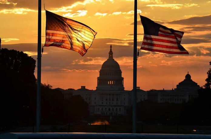U.S. Capitol silhouette with American flags at sunset
