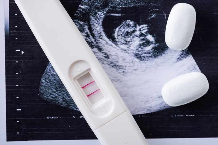 shutterstock_1506812507 Pregnancy test with two lines on an ultrasound print
