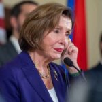 Pelosi Revisits What She Knew About Biden woman in purple suit speaking at a microphone