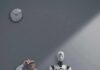 Man and humanoid robot sitting in a waiting room