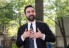 Boos Explode: NYC Mayor Flees Stage Man in suit speaking with hands on chest outdoors