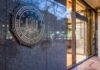 FBI emblem on a stone wall beside a glass entrance