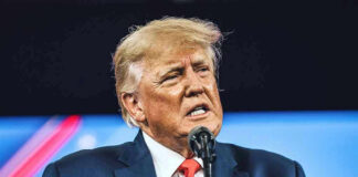Donald Trump speaking at a podium with a microphone