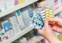 Dem Denial Collides With Costly Receipts Hands holding blister packs of assorted pills in a pharmacy